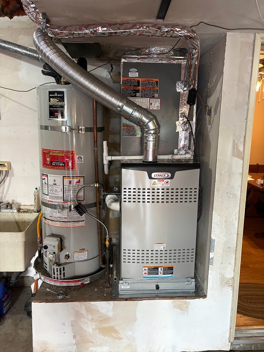 Lennox furnace installed beside a residential gas water heater in a compact utility area