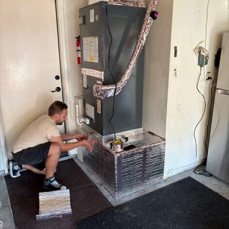 Technician working on indoor HVAC equipment during installation